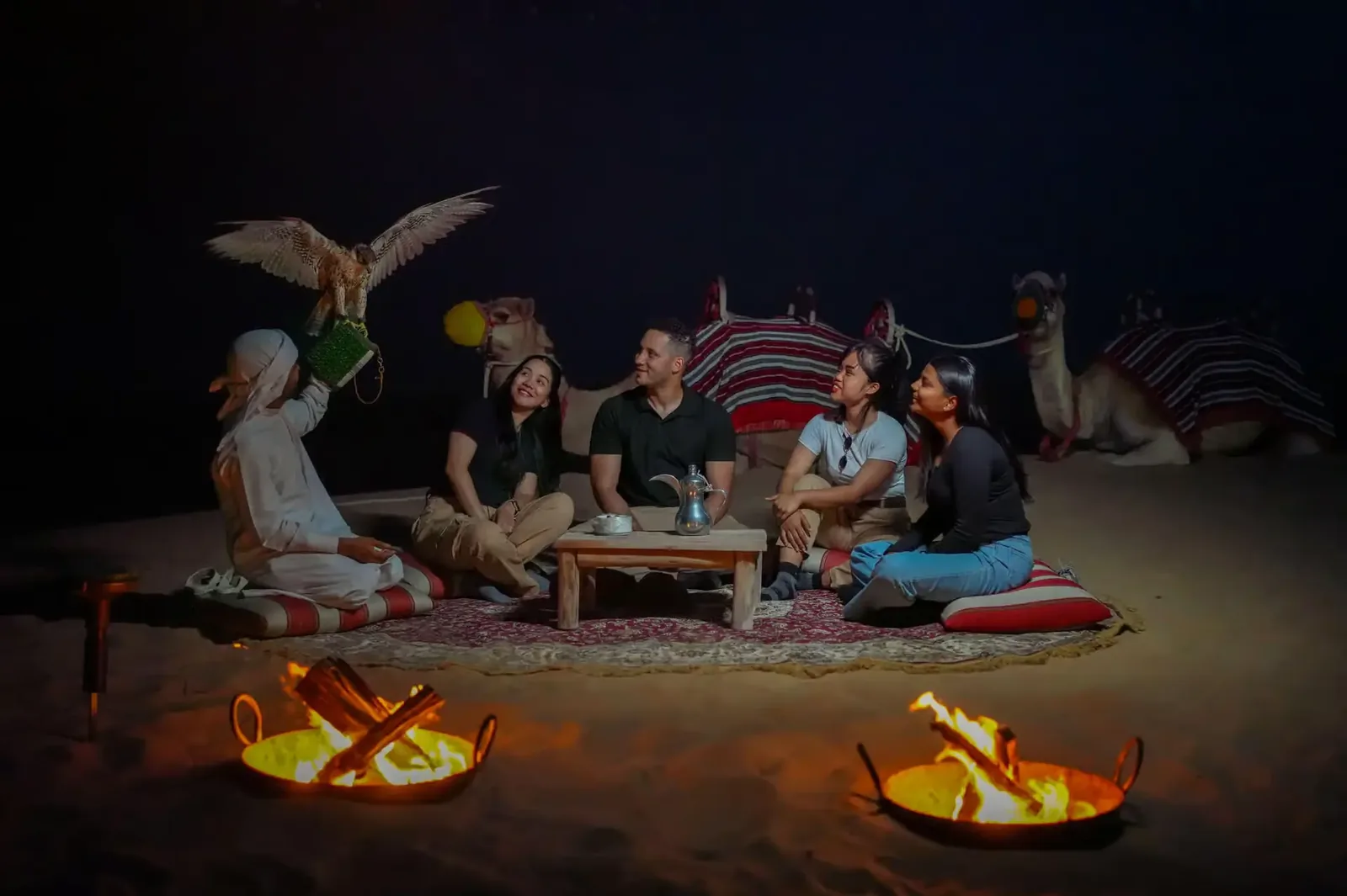 Evening desert camp with falcon show, camels and fire pits on an Overnight Desert Safari in Abu Dhabi